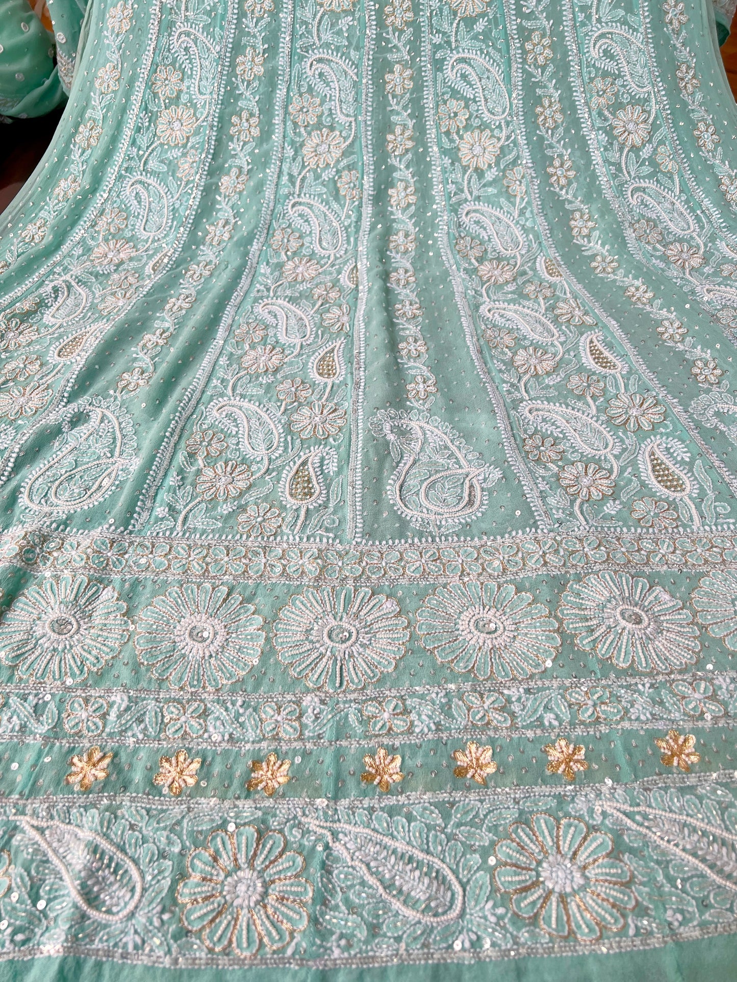 Mint green Anarkali featuring intricate Chikankari embroidery and embellishments on luxurious Georgette fabric.