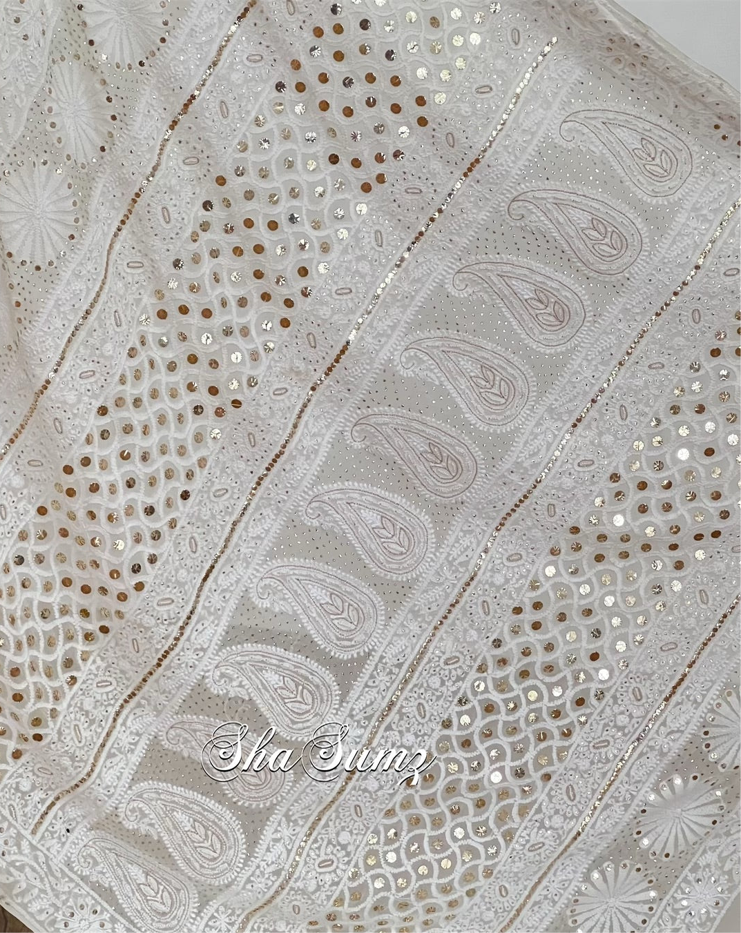 Lily white saree featuring Chikankari, Mukaish work, and pearls close up