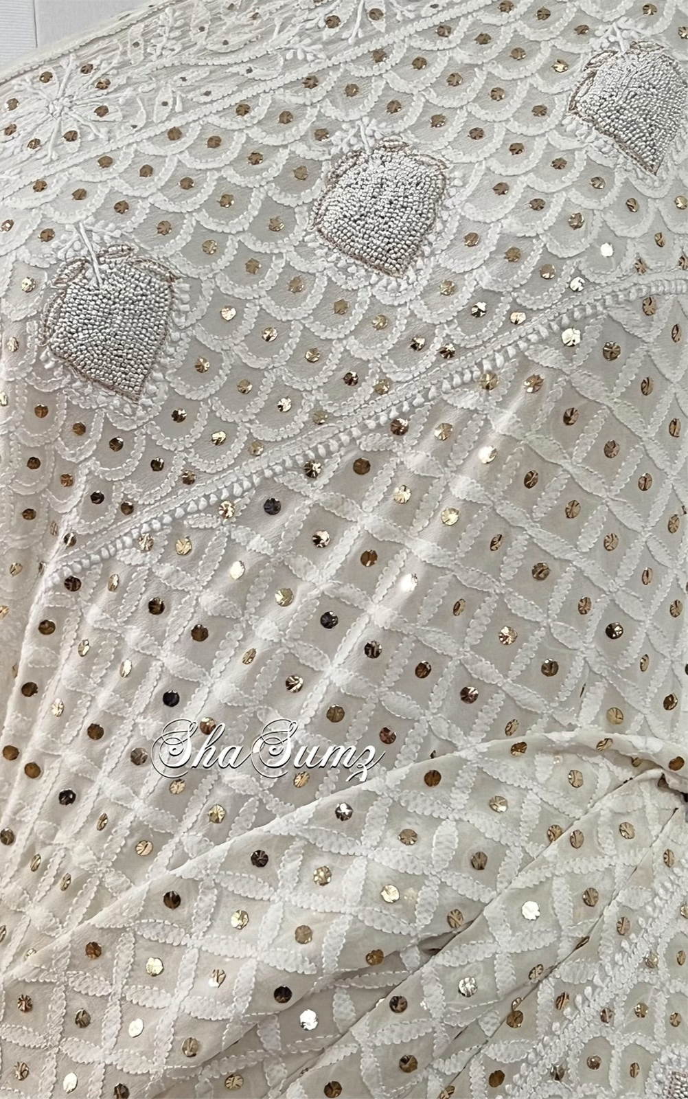 Lily white saree featuring Chikankari, Mukaish work, and pearls close up