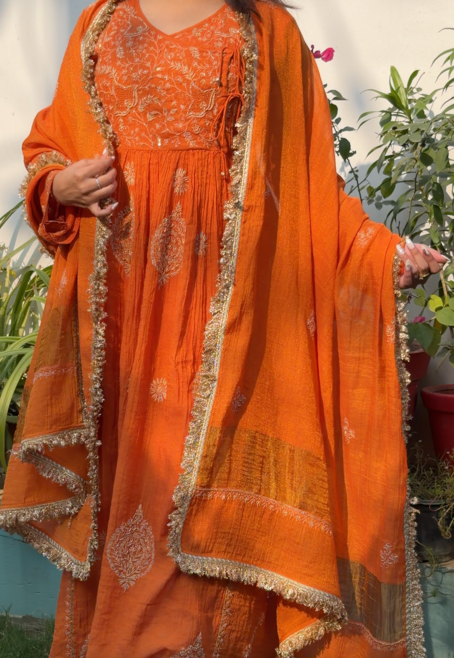 Rust Orange Tissue Angarkha with Chikankari worn with a matching embroidered shawl against a garden backdrop.