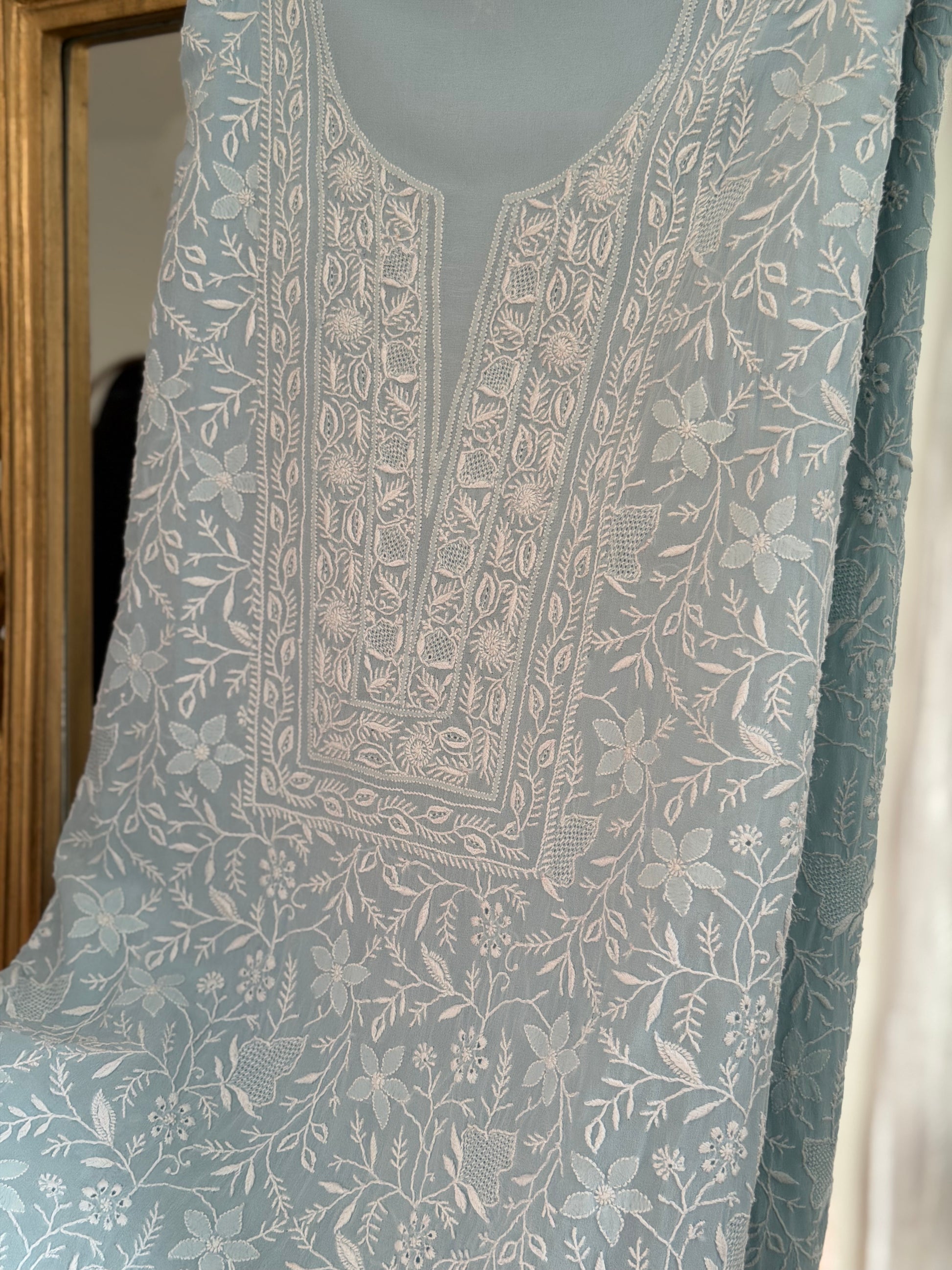 Powder blue pure georgette suit with do Taar chikankari, showcasing detailed floral embroidery design.