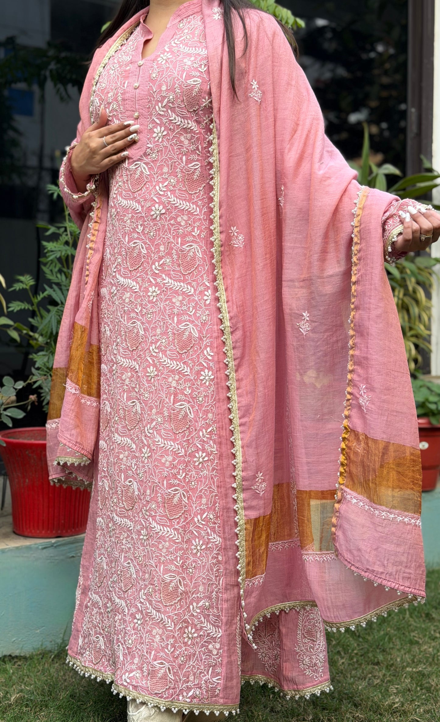 Dusty Rose Tissue Chanderi Chikankari Anarkali featuring intricate embroidery and elegant drape, model wearing it outdoors.