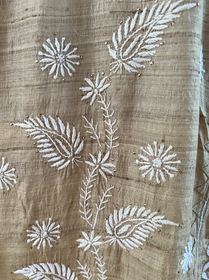 Close-up of hand-embroidered Pure Tussar Silk Chikankari design featuring floral patterns on luxurious fabric.